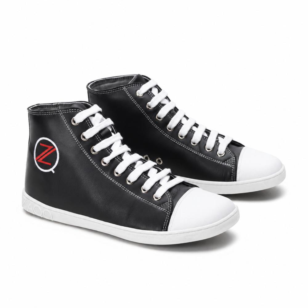 Une paire de baskets montantes noires classiques de ZAQQ CHUQQS a des lacets et des embouts blancs, chacun arborant un logo Z rouge et blanc frappant. Les semelles sont en caoutchouc durable, ce qui donne aux chaussures un look tendance légèrement usé.