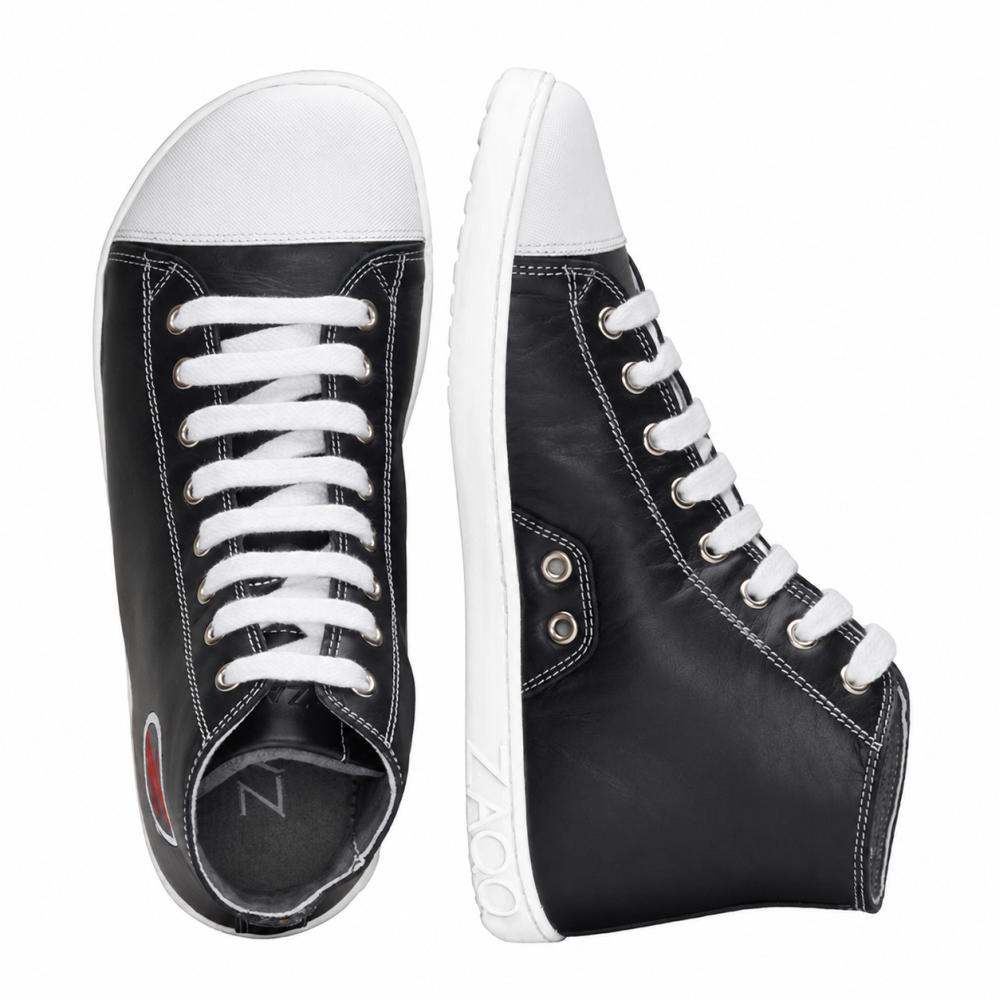 Une paire de baskets montantes noires stylées de ZAQQ CHUQQS avec une semelle en caoutchouc blanc et des lacets. La chaussure gauche est debout, tandis que la chaussure droite est couchée sur le côté et montre un logo chic près du talon.