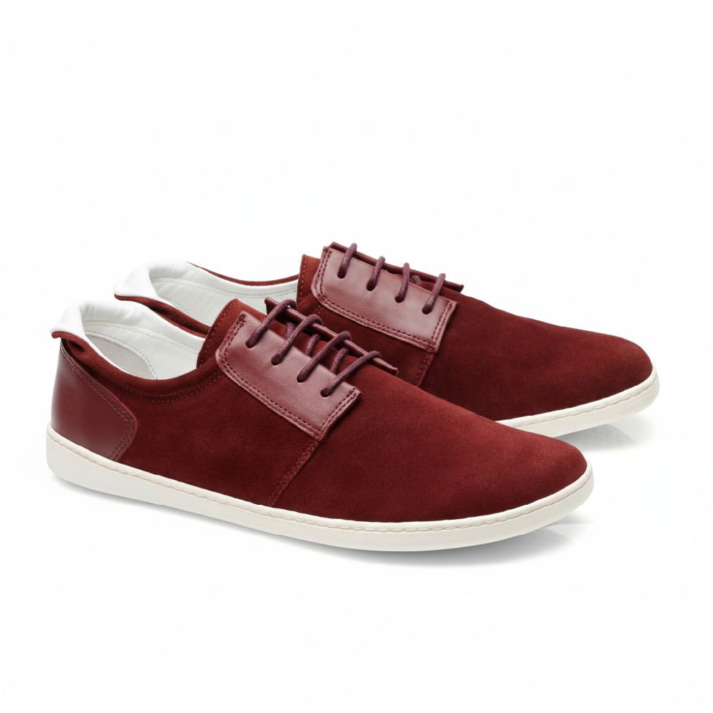 Ein Paar PIQUANT Bordeaux von ZAQQ bietet ein stilvolles Barfuß-Sneaker-Design mit bordeauxrotem Leder und weißer, flexibler Sohle. Es verfügt über Lederakzente und passende Schnürsenkel für einen schlanken, modernen Look, der sich perfekt für die Freizeit eignet.