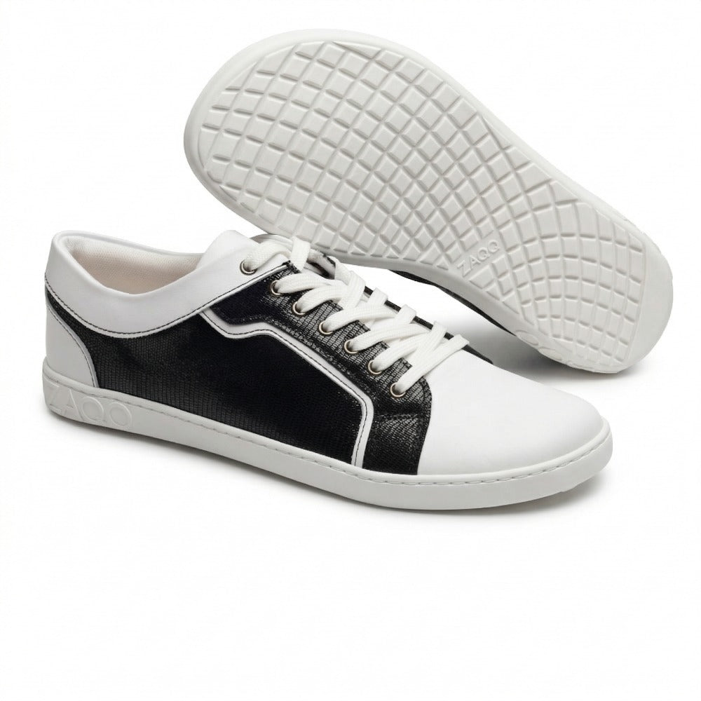 Die ZAQQ QODY White Sneaker bestechen durch ihr stylisches Design mit weißer Sohle und schwarzen strukturierten Seitenteilen aus hochwertigem Nappaleder. Sie verfügen über weiße Schnürsenkel und einen Zehenbereich sowie das ZAOO-Logo an der Seite. Das auffällige Sohlenmuster verleiht diesen Sneakern einen auffälligen, modernen Touch.