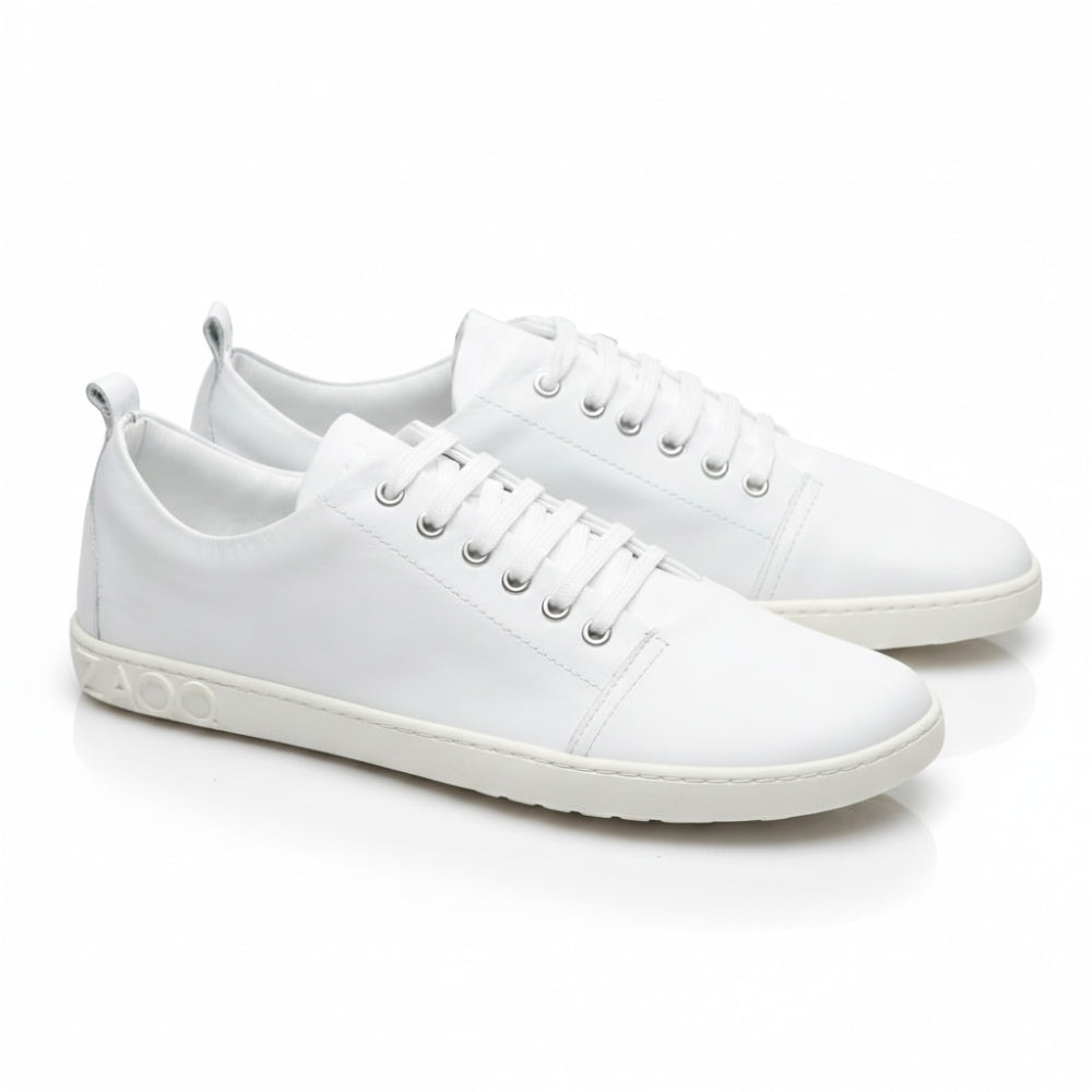 Der ZAQQ TAQQ Nappa White Sneaker ist ein weißer Low-Top mit Schnürung aus Nappaleder, im minimalistischen Design mit silbernen Metallic-Akzenten an der Seitensohle und einer flexiblen Kautschuksohle für hohen Tragekomfort.